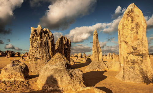 Panoramic view of rocks on landscape against cloudy sky