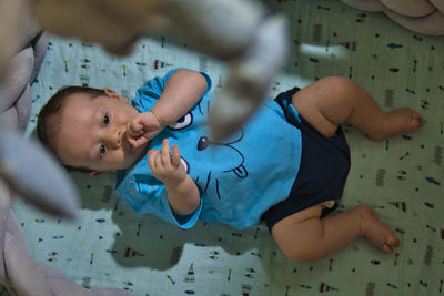 High angle view of cute baby lying down on bed