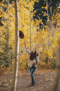 Full length of woman standing in forest during autumn