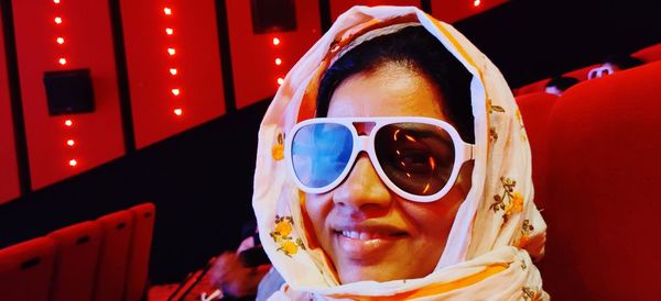 Close-up portrait of woman wearing 3-d glasses in movie theater