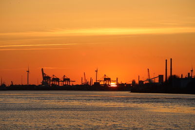 Industry against sky during sunset