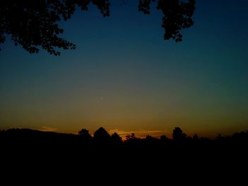 Scenic view of landscape against clear sky at sunset