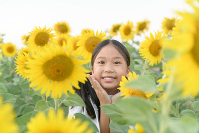 Portrait of smiling girl amidst sunflowers