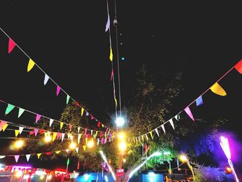 Low angle view of illuminated lights against sky at night
