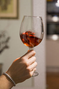 Female arm swirling a rose wine glass