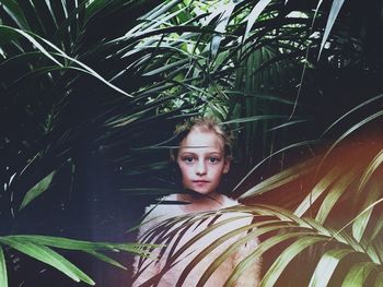 Portrait of girl standing by plants