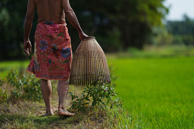 Low section of woman standing on field