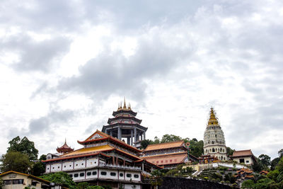 Low angle view of buildings against cloudy sky