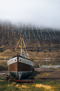 Sailboat moored on land against sky