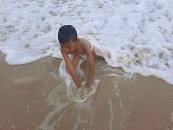 Full length of shirtless boy on beach
