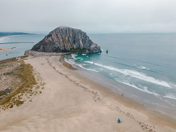 Aerial view of morro bay rock over looking the beach and ocean on a gray foggy day