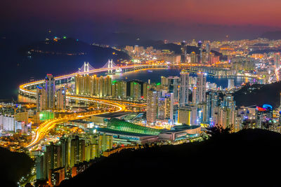 Illuminated modern buildings against sky at night