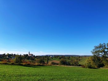 Scenic view of field against clear blue sky