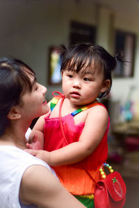 Mother carrying daughter at home