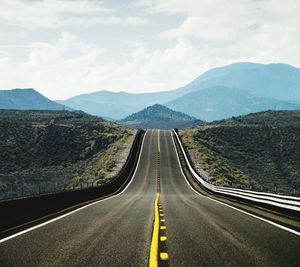 Empty road along countryside landscape