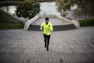 Male athlete running on steps at park