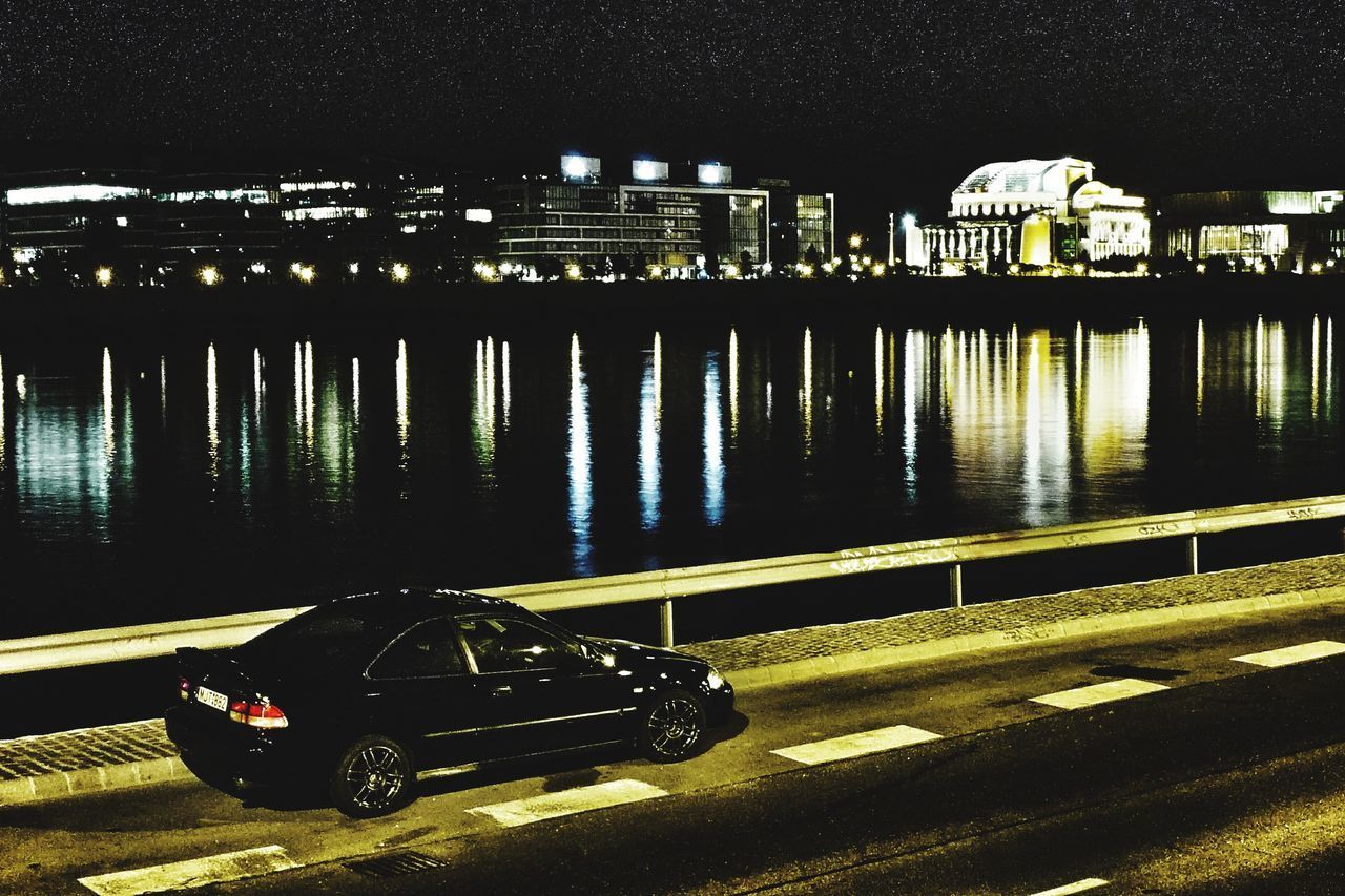 VIEW OF CAR ON ILLUMINATED ROAD AT NIGHT