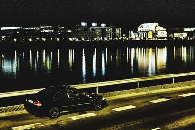 Cars on illuminated road in city at night