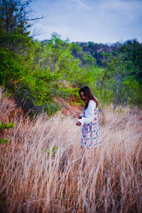 Woman standing on field against sky