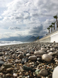 Surface level of stones on beach against sky