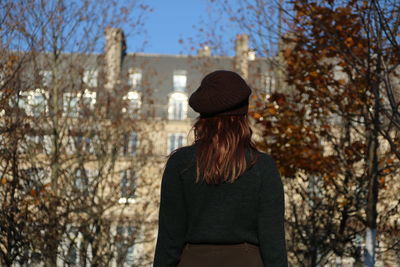 Woman wearing hat against trees in winter