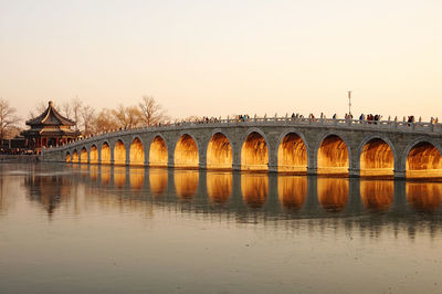 Arch bridge over river against clear sky