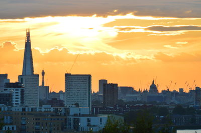 Buildings in city against sky during sunset