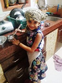 Portrait of smiling girl holding while standing at home