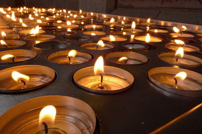 Close-up of illuminated candles in temple