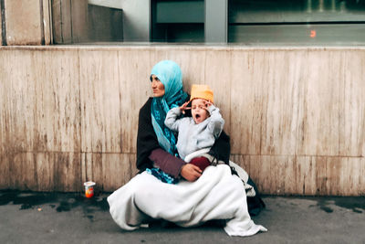 Full length of mother and daughter sitting on floor