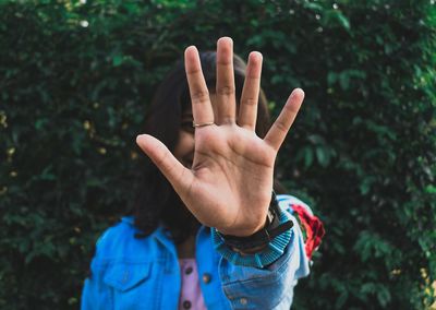 Cropped image of hand against tree