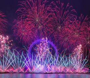 Low angle view of firework display at night