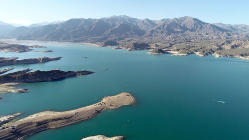 High angle view of sea and mountains against sky