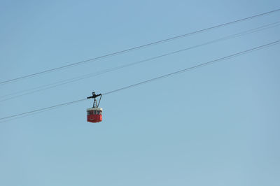 Low angle view of power lines against clear blue sky