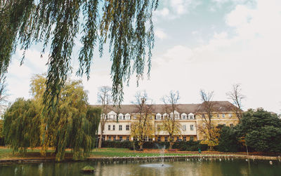 Building by lake against sky