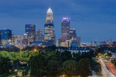 Illuminated buildings in city against sky at night