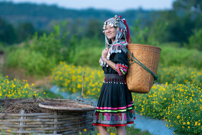 Woman holding umbrella standing against plants