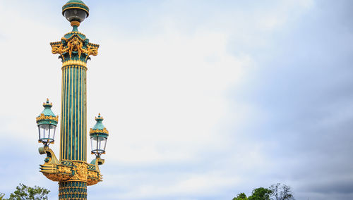 Low angle view of statue of temple against cloudy sky