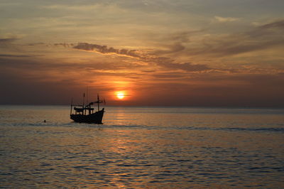 Silhouette boat in sea against sky during sunset