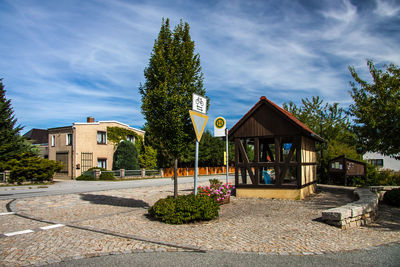 Houses by footpath against sky in city