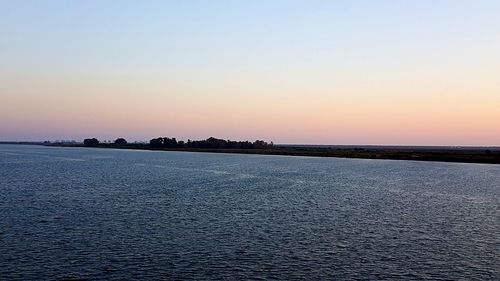 Scenic view of sea against clear sky during sunset