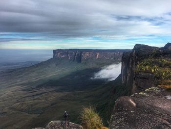 Scenic view of land and mountains against sky