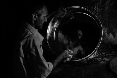 Man cleaning musical instrument against wall