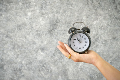 High angle view of hand holding clock