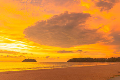 Scenic view of sea against dramatic sky during sunset