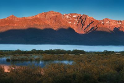 Scenic view of lake and mountains against clear sky