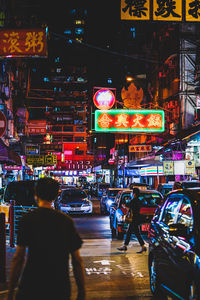 People on illuminated city street at night