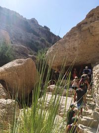 People standing on mountain against clear sky