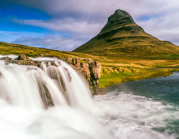 Scenic view of waterfall against sky