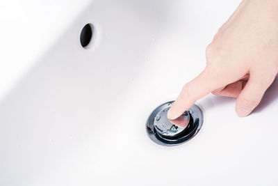 Close-up of person touching sink in bathroom